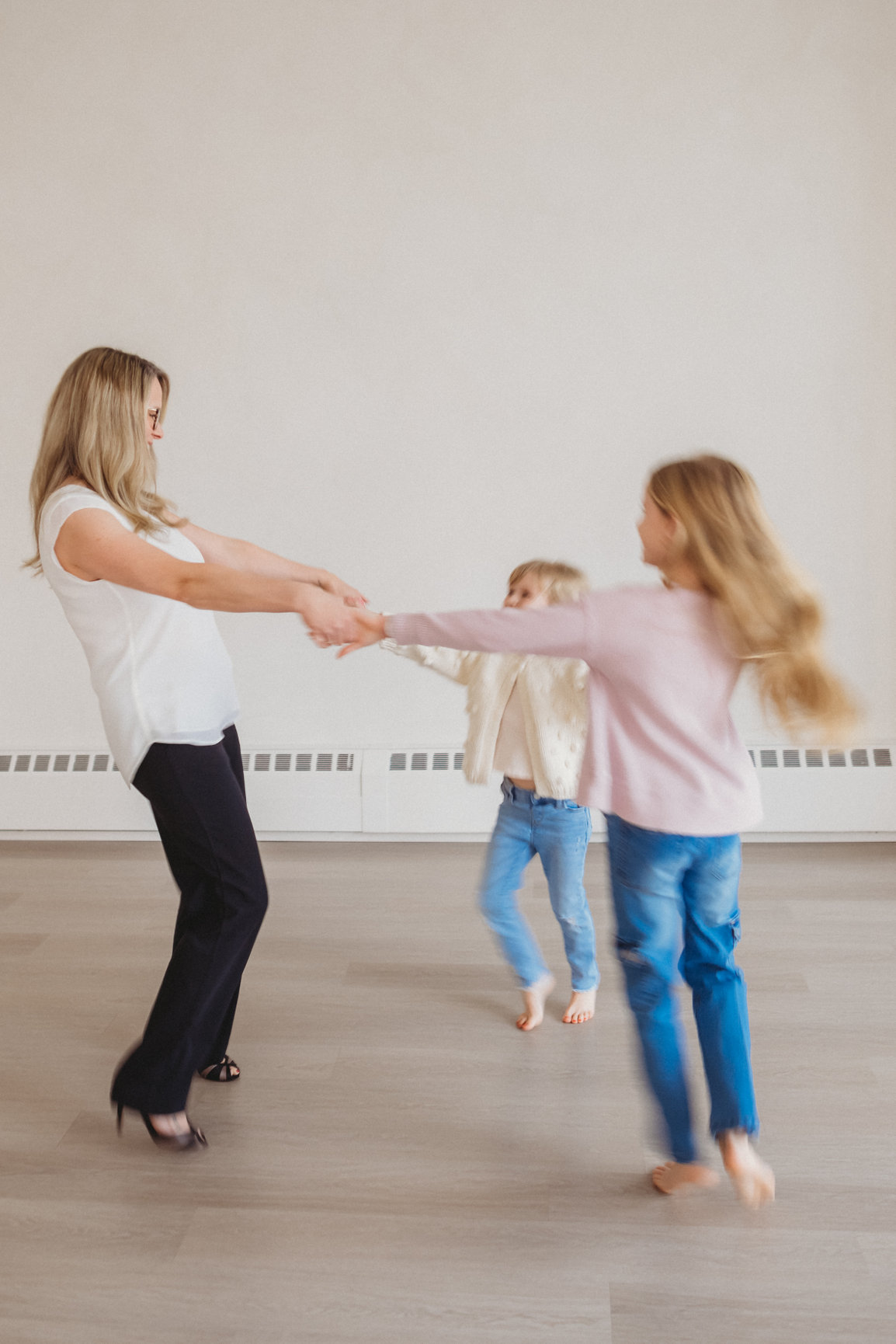 Sarah Hope laughing and playing with her two daughters in joyful motion, warm natural light